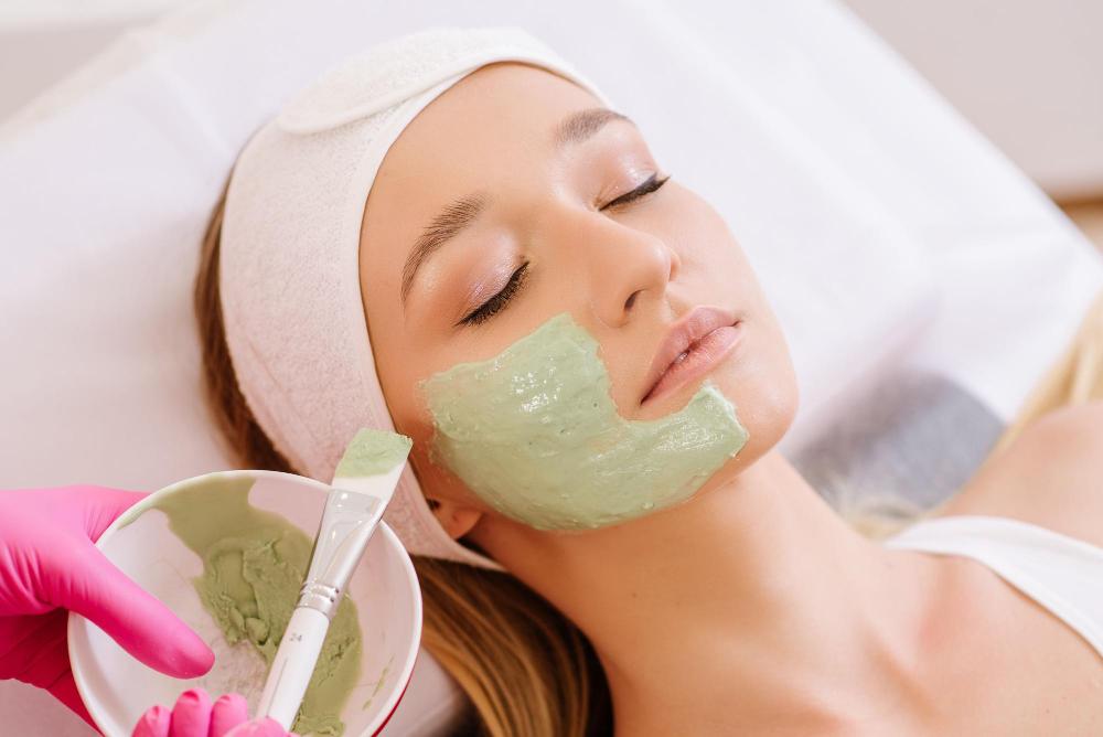 cosmetologist-applying-mask-face-woman-spa-salon